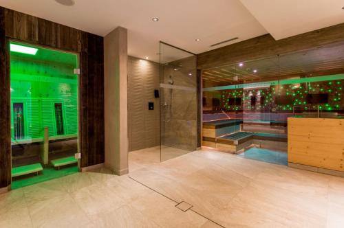 a bathroom with a shower and a swimming pool at Alpenhotel Ischglerhof in Ischgl