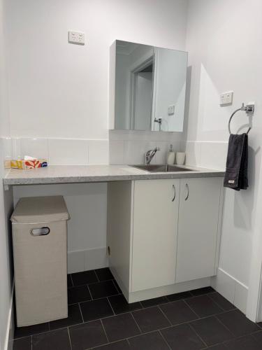 a white bathroom with a sink and a mirror at The Shed Bed & Breakfast in Hay