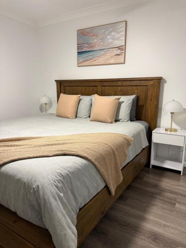a bedroom with a large bed with a wooden headboard at The Shed Bed & Breakfast in Hay