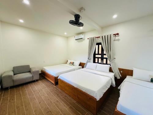a room with two beds and a chair in it at Núp Gió Cottages in Ấp Mỹ Hải