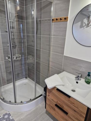 a bathroom with a shower and a sink at Chatki przy Marinie in Wapnica