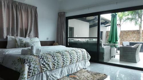 a bedroom with a bed and a sliding glass door at villa km22 in Assinie