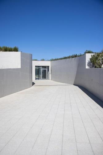 an empty parking lot with a concrete wall at Kai House in Lun