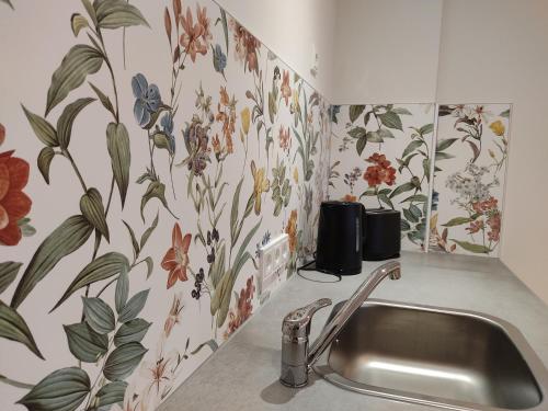 a kitchen with floral wallpaper on the wall and a sink at Gästezimmer alte Schneiderei in Duderstadt