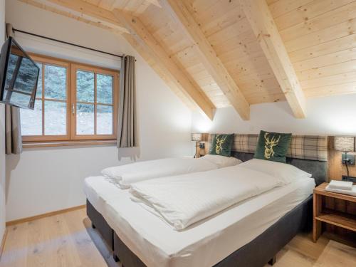 a large bed in a room with a window at Ahorn Mountainlodge in Donnersbachwald