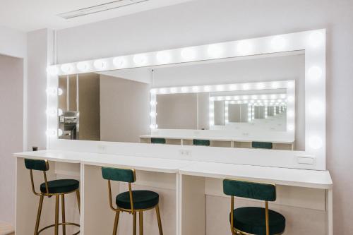 a bathroom with a counter with stools and a mirror at Meworld Hotel - Taipei Main Station in Taipei