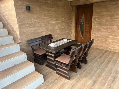 a wooden table and chairs in a room with stairs at Apartmani Fenix 29 in Ljubovija