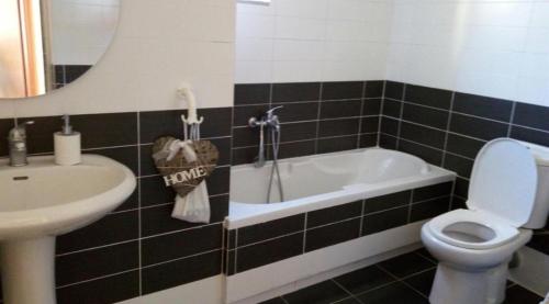 a bathroom with a tub and a toilet and a sink at Elena's Hotel & apartments in Sarandë