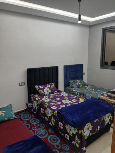 a bedroom with two beds and a mirror at تجزئة الفتح 925 خريبكة 3 in Khouribga