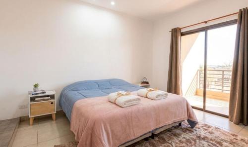 a bedroom with a bed with two towels on it at La soñada in Salta