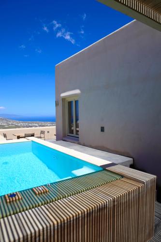 a swimming pool in front of a house with the beach at Voreina Gallery Suites in Pirgos