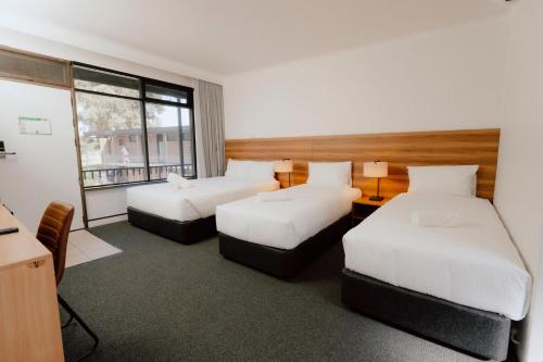 a hotel room with two beds and a window at Canberra Park Motel in Canberra