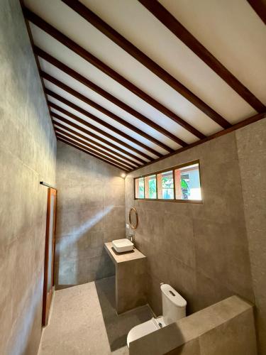 a bathroom with a toilet and a sink at VILLA Santay byAdiba in Gili Islands