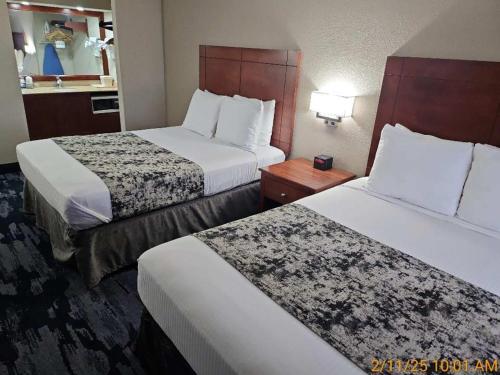 a hotel room with two beds with white sheets at Best Western Montis Inn in Saint Robert