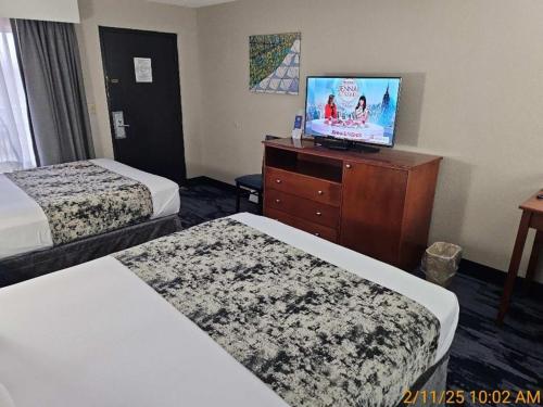 a hotel room with two beds and a flat screen tv at Best Western Montis Inn in Saint Robert