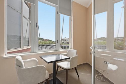 a room with a table and chairs and windows at The Cliff Suites in Golem