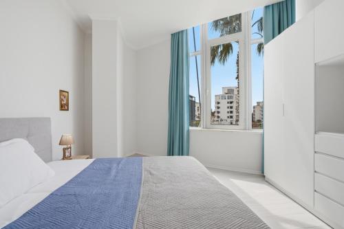 a bedroom with a bed and a large window at The Cliff Suites in Golem
