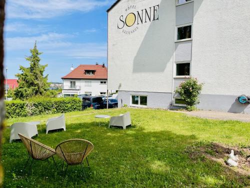 a group of chairs in the grass in front of a building at LEO Apartments in Leonberg