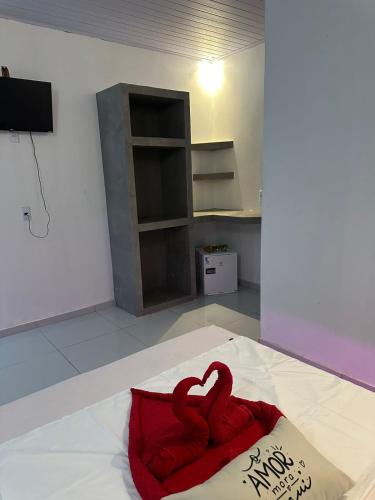 a red towel on a bed in a room at Pousada sonho real in Barreirinhas