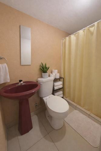 a bathroom with a toilet and a sink at Tico-living in Alajuela