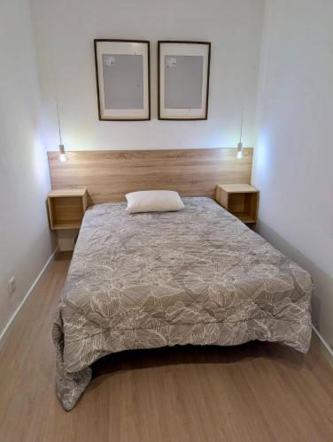 a bed in a bedroom with two pictures on the wall at Casa do Picadeiro in Elvas
