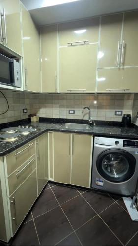 a kitchen with a sink and a washing machine at بورتو مطروح - القبطان in Marsa Matruh