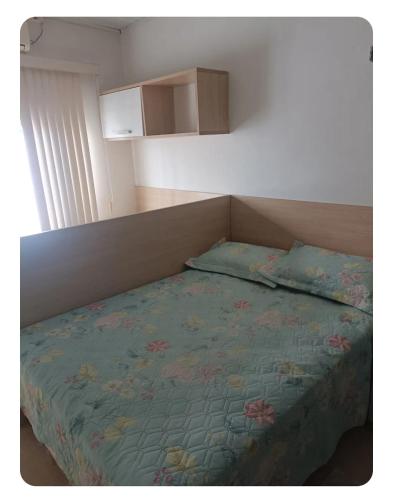 a bedroom with a bed with a blue comforter at Simplicidade e localização privilegiada no coração de Adrianópolis em Manaus in Manaus