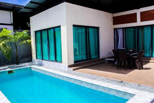 a house with a swimming pool and a table and chairs at villa km19 in Assinie