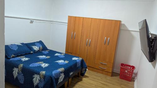 a bedroom with a bed and a wooden cabinet at Residencia cercana ENGIE in Tocopilla