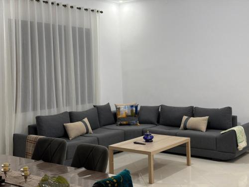 a living room with a blue couch and a table at Luxury Terrace Apartment in Al Hoceïma