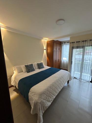 a bedroom with a large bed with a blue and white blanket at Boutique Exclusive Stay in Baños