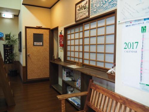 a room with a wall with a door and a book shelf at Sudomari Minshuku Friend in Yakushima