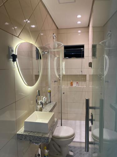 a bathroom with a sink and a toilet and a mirror at Casa Nova, 2 quartos, 1 Ar-Cond, 1 Banheiro, Garagem 4,30m in Montes Claros