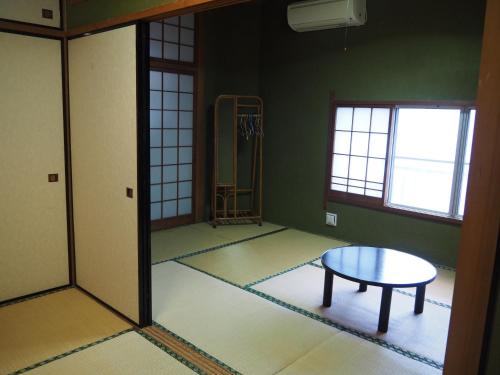an empty room with a table and a window at Sudomari Minshuku Friend in Yakushima