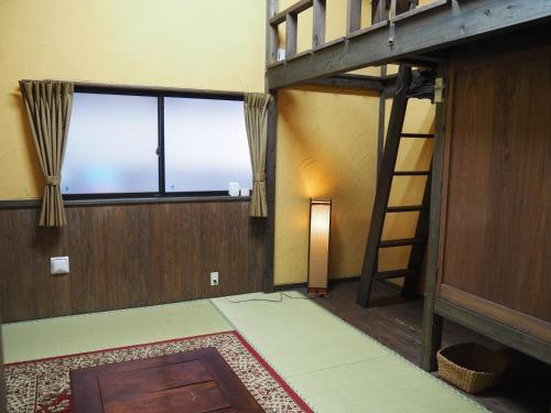 a room with a bunk bed and a ladder at Sudomari Minshuku Friend in Yakushima