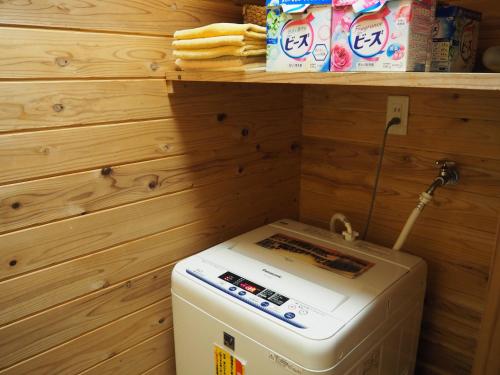 a small refrigerator in a kitchen with a shelf at Sudomari Minshuku Friend in Yakushima