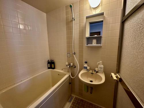 a bathroom with a sink and a bath tub and a sink at Tesoro Okushiga in Yamanouchi