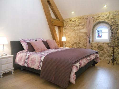 1 dormitorio con cama con sábanas rosas y ventana en Les Mille et une Pierres en Mareuil-le-Port
