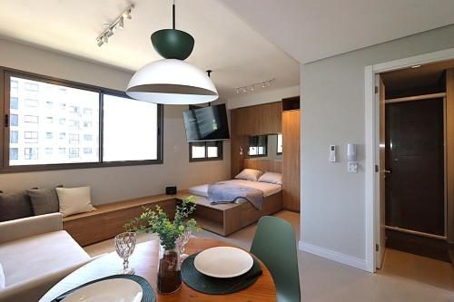 a living room with a couch and a table in a room at MOOD Modern Studio, Central Parque in Porto Alegre