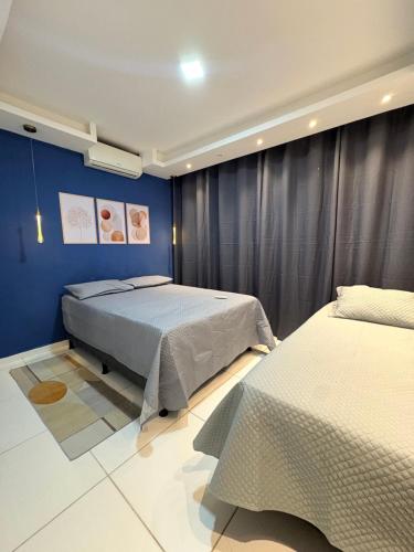 a bedroom with two beds and a blue wall at Apartamento com piscina e lazer completo - ideal para família in Caruaru