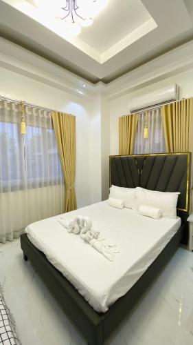 a bedroom with a large bed with white sheets at Mira Transient in Bantay