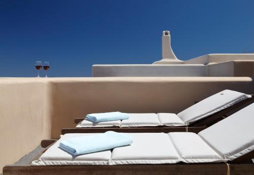 a row of white chairs on the side of a building at Voreina Gallery Suites in Pirgos