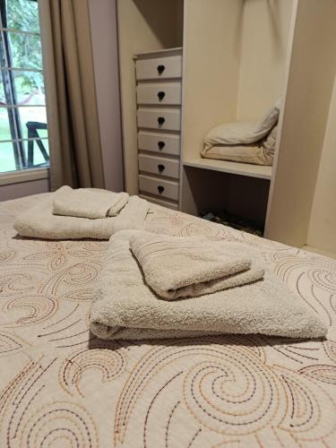 a bedroom with two beds with towels on them at El Descanso in Las Flores