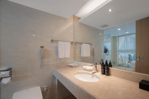 a bathroom with a sink and a mirror at Jin Jiang West Capital International Hotel in Xi'an