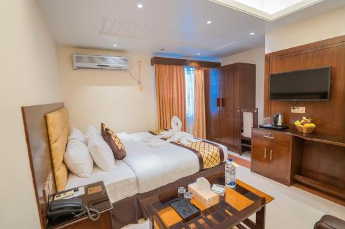 a hotel room with a bed and a television at Central Inn Hotel & Spa in Dhaka