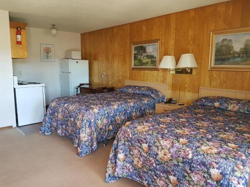a hotel room with two beds and a refrigerator at Alberni Inn in Port Alberni