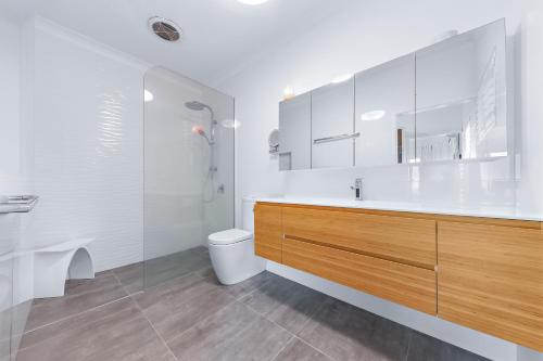 a white bathroom with a sink and a toilet at Ocean's Edge in Cannonvale