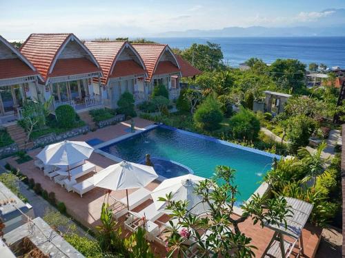 an overhead view of a swimming pool with umbrellas at Darya Sea View by ABM in Nusa Penida