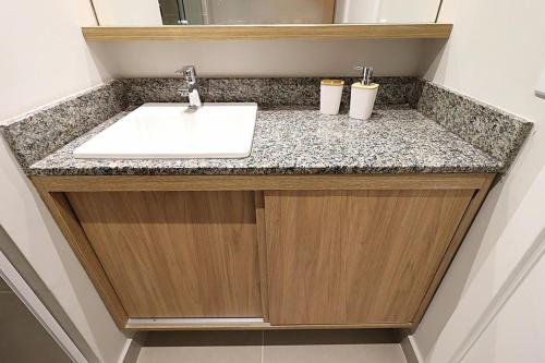 a bathroom counter with a sink and two cups on it at MOOD Modern Studio, Central Parque in Porto Alegre