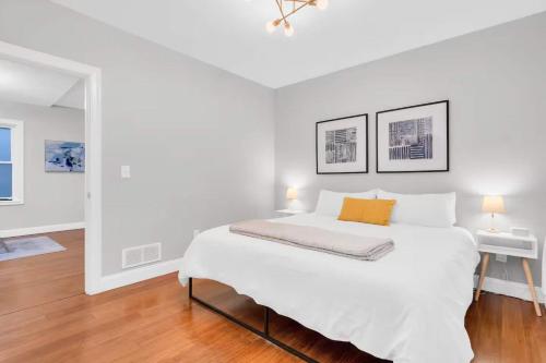 a white bedroom with a large bed and a table at Jennifer's Chic Modern 1st Floor Apt Private Patio in Providence